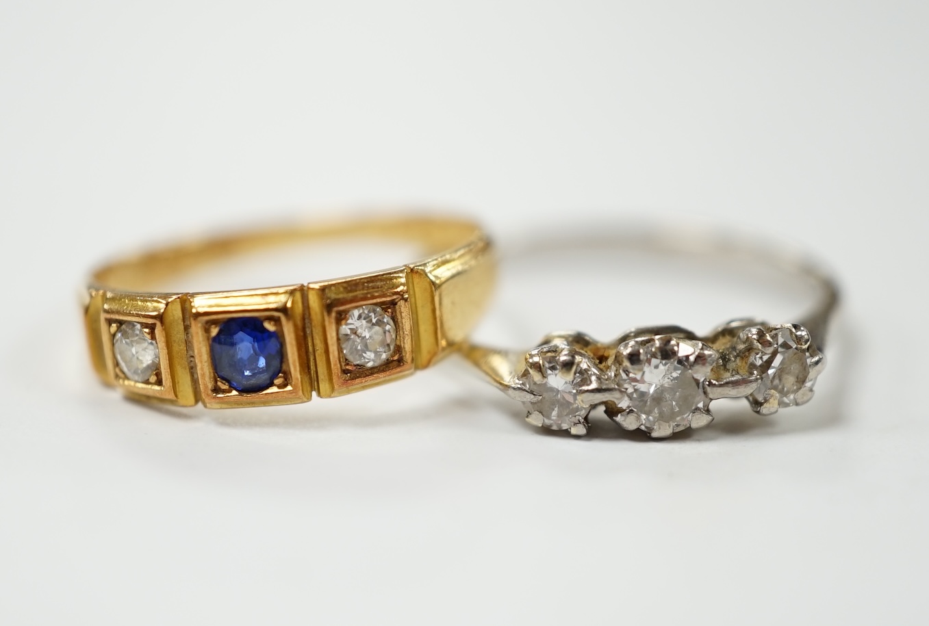 An Edwardian 18ct gold sapphire and diamond set three stone ring, size L, together with a white metal and three stone diamond ring, size N, gross weight 4.7 grams. Condition - fair